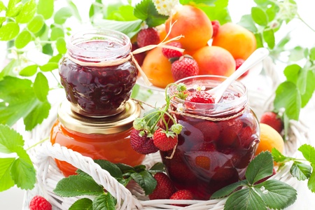 strawberry,apricot, raspberry jam in a jars and fresh berriesの写真素材