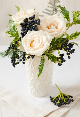 Christmas arrangement of roses,winter berries and hollyの写真素材