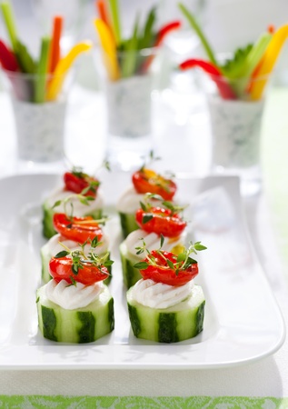 Holiday vegetable appetizers.Cucumbers with soft cheese and sun dried tomatoes and vegetable sticks with dipの写真素材