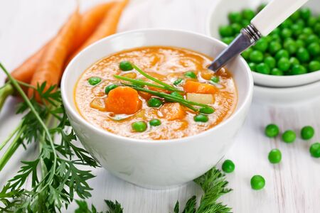 Fresh vegetable soup with carrot, potato and green peaの写真素材