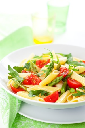 Pasta penne with asparagus,tomato and rucola in bowlの写真素材
