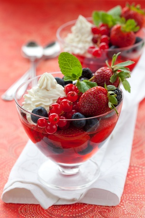 Berries in jelly  with cream and fresh fruits in glassesの写真素材