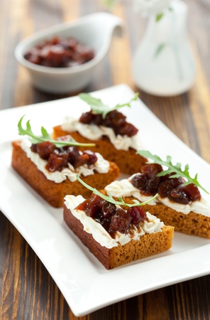 Pumpkin and tomato chutney on pumpkin bread with soft cheeseの写真素材