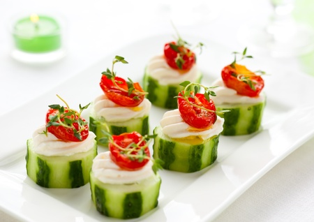 Holiday vegetable appetizers with cucumbers, soft cheese and sun dried tomatoesの写真素材