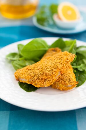 breaded fish with spinachの写真素材