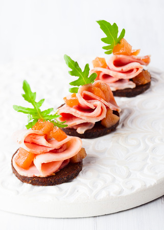Slices of bread with ham and pear chutney for holidayの写真素材