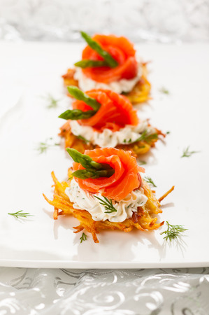 Potato pancakes topped with smoked salmon,asparagus and sour cream for holidayの写真素材