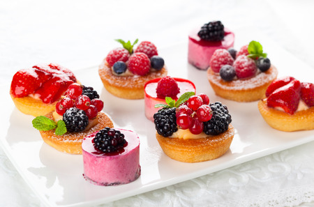 Assorted fruit tartlets and pieces of cakes for holiday Assorted fruit tartlets and pieces of cakes for holiday