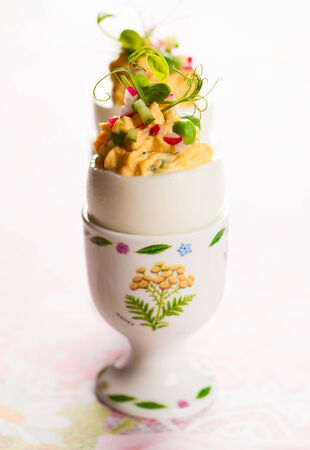 Stuffed eggs filled with cucumber,radish and green pea for Easterの写真素材