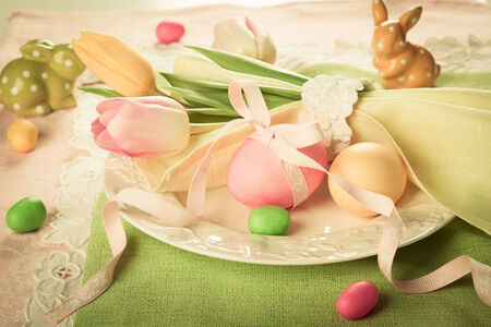 Vintage style Easter table setting with tulips and easter eggsの写真素材