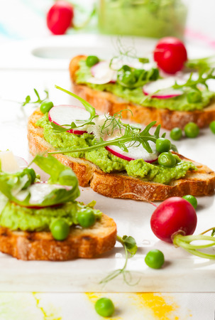 Crostini with pea puree,radish,rocket and cheeseの写真素材