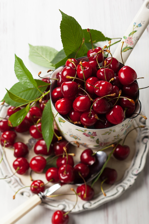 Fresh cherries in pot on the tableの写真素材