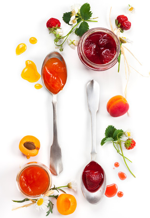 Apricot and strawberry jam with fresh berries on white backgroundの写真素材