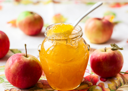 Apple jam in a jar and fresh red applesの写真素材