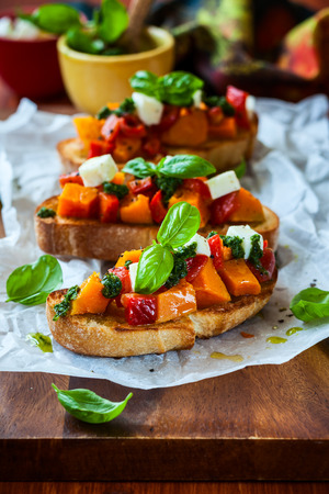Bruschetta with roasted pumpkin, red pepper,pesto and cheeseの写真素材