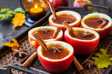 Apple cider with cinnamon sticks and anise star in apple cupsの写真素材