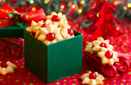 Christmas cookies with red candied cherries in the green gift boxの写真素材