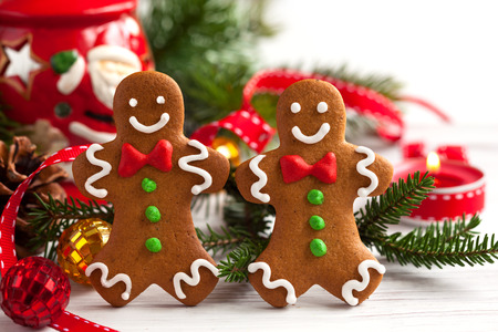 Smiling gingerbread men on white wooden backgroundの写真素材