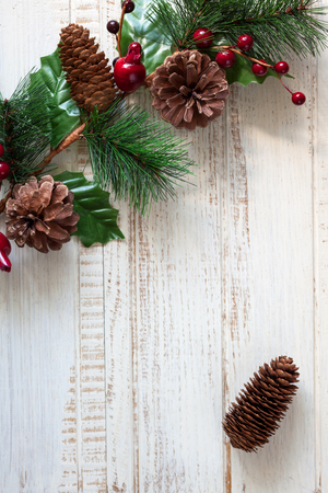 Christmas background with fir branches,pinecones and berries on the old wooden boardの写真素材