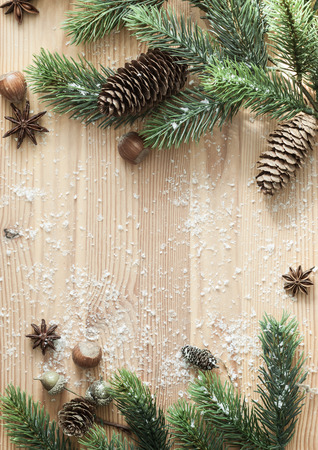 Christmas background with fir branches,pinecones and berries on the old wooden board.Vintage styleの写真素材