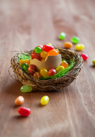 colorful Easter candy eggs in nest on the wooden table.soft focusの写真素材
