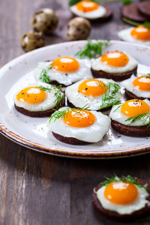 Preparation quail egg canapes with pumpernickel bread for Easterの写真素材