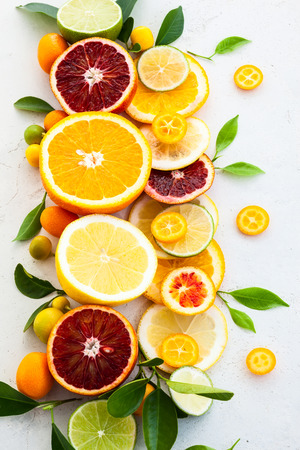 Assorted fresh citrus fruits with leavesの写真素材