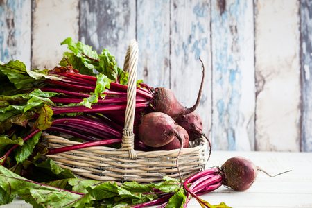 Fresh organic beetroot with green leaves in a basketの写真素材