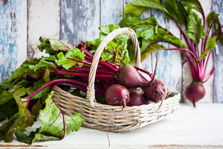 Fresh organic beetroot with green leaves in a basketの写真素材