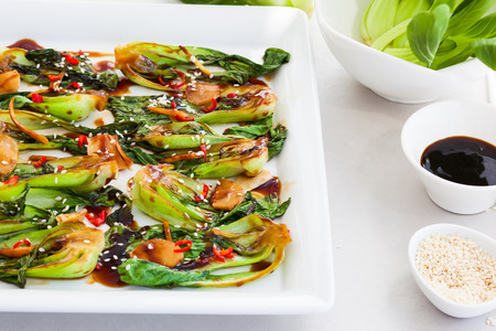 Roasted baby bok choy with spicy sauce and sesame seedsの写真素材