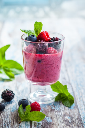 Delicious blackberryraspberry and blueberry smoothie garnished with fresh berries in glassの写真素材