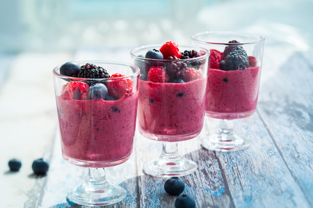 Delicious blackberryraspberry and blueberry smoothie garnished with fresh berries in glassesの写真素材