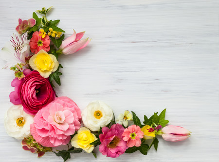 Flowers frame on white wooden background. Top view with copy spaceの写真素材