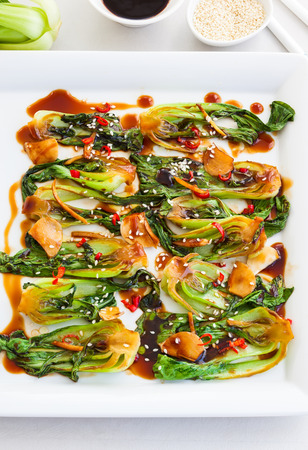 Roasted baby bok choy with spicy sauce and sesame seedsの写真素材
