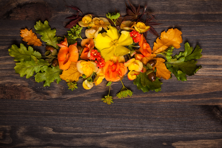 Autumnal flowers and berries on vintage wooden background. Top view with copy spaceの写真素材