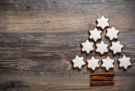Christmas background with gingerbread cookies,christmas lights and spices on the old wooden boardの写真素材