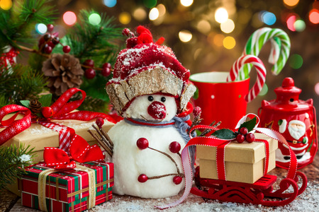 Snowman, Christmas presents and sweets  over wooden backgroundの写真素材