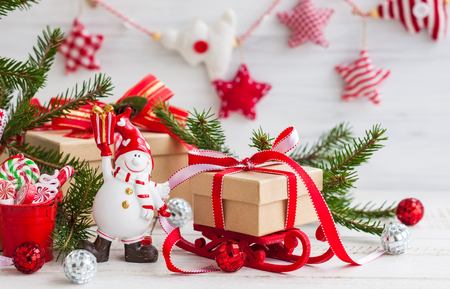 Snowman and gift boxes  on the white wooden backgroundの写真素材