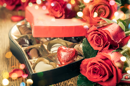 Heart shaped box of chocolate truffles with red rosesの写真素材