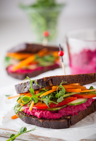 gluten free vegan sandwiches with beet hummus, raw vegetables and sproutsの写真素材