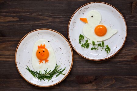 Easter breakfast for kids with shaped fried eggs  on a  plateの写真素材