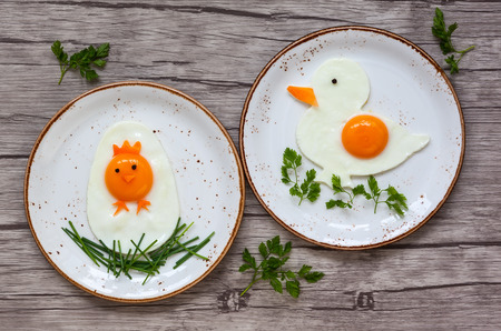 Easter breakfast for kids with shaped fried eggs  on a  plateの写真素材