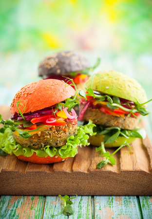 Red, green, black mini burgers with quinoa and vegetablesの写真素材