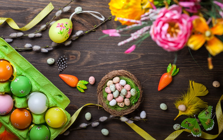 Easter decorations  with colorful eggs and sweet candy over wooden backgroundの写真素材