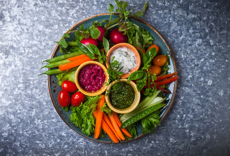 Veggie crudite platter with three different dips on the metal backgroundの写真素材