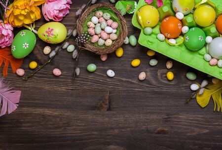 Easter decorations  with colorful eggs and sweet candy over wooden background