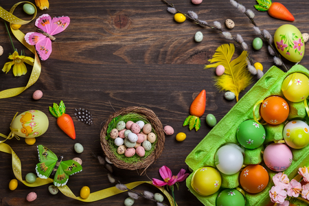 Easter decorations  with colorful eggs and sweet candy over wooden backgroundの写真素材