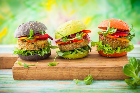 Red, green,black mini burgers with quinoa and vegetablesの写真素材