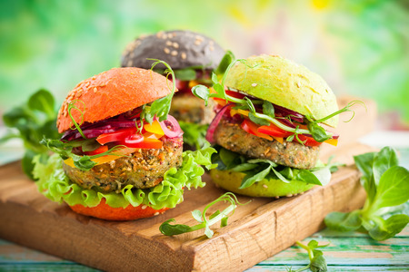 Red, green,black mini burgers with quinoa and vegetablesの写真素材