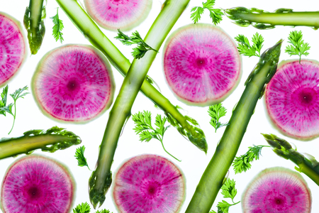 Thin slices of fresh vegetables on a white background